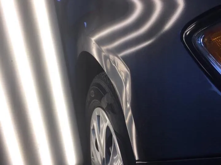 Paintless dent repair of a dent on a car quarter panel — before
