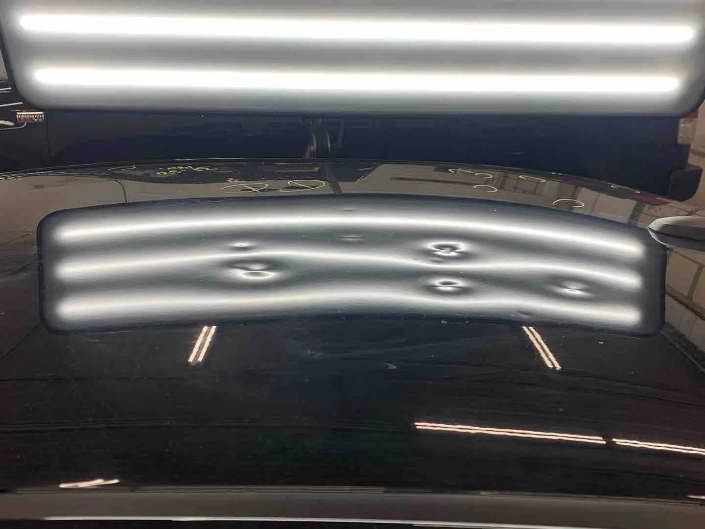 Hail damage repair on a car roof — before